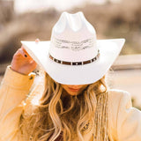 Person wearing a white cowboy hat with a blurred background